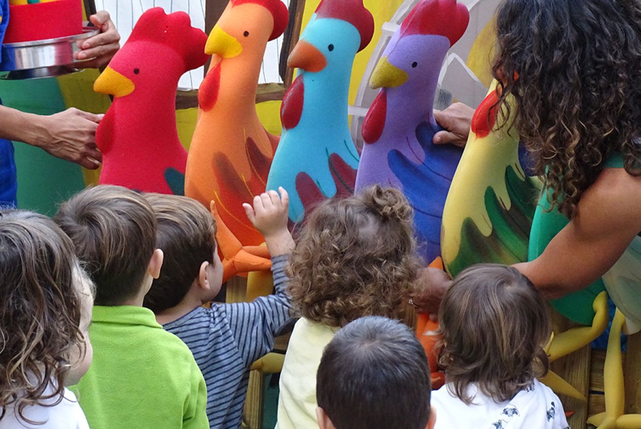 Renata enseñando los gallos a los niños